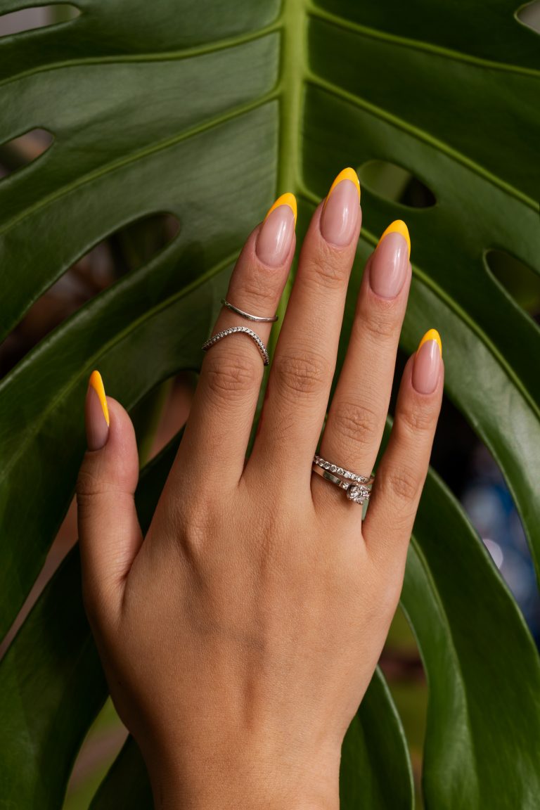 woman-showing-her-nail-art-fingernails-against-monster-leaf